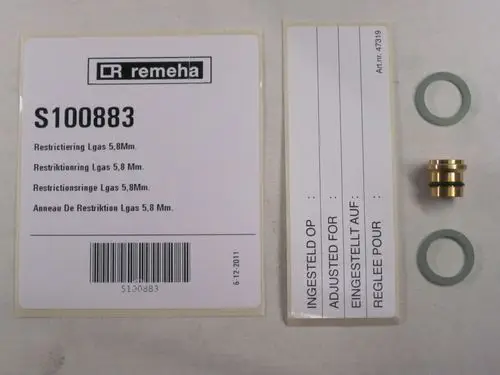 Zwei Produktetiketten von Remeha, ein goldfarbener Drosselring mit O-Ringen sowie eine beige Packung mit Barcode, alle auf einer neutralen Oberfläche angeordnet.